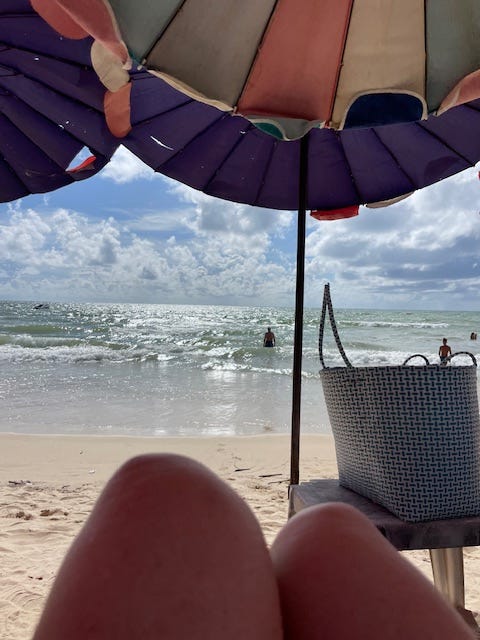 beach scene looking out to sea from umbrella covered sunbed