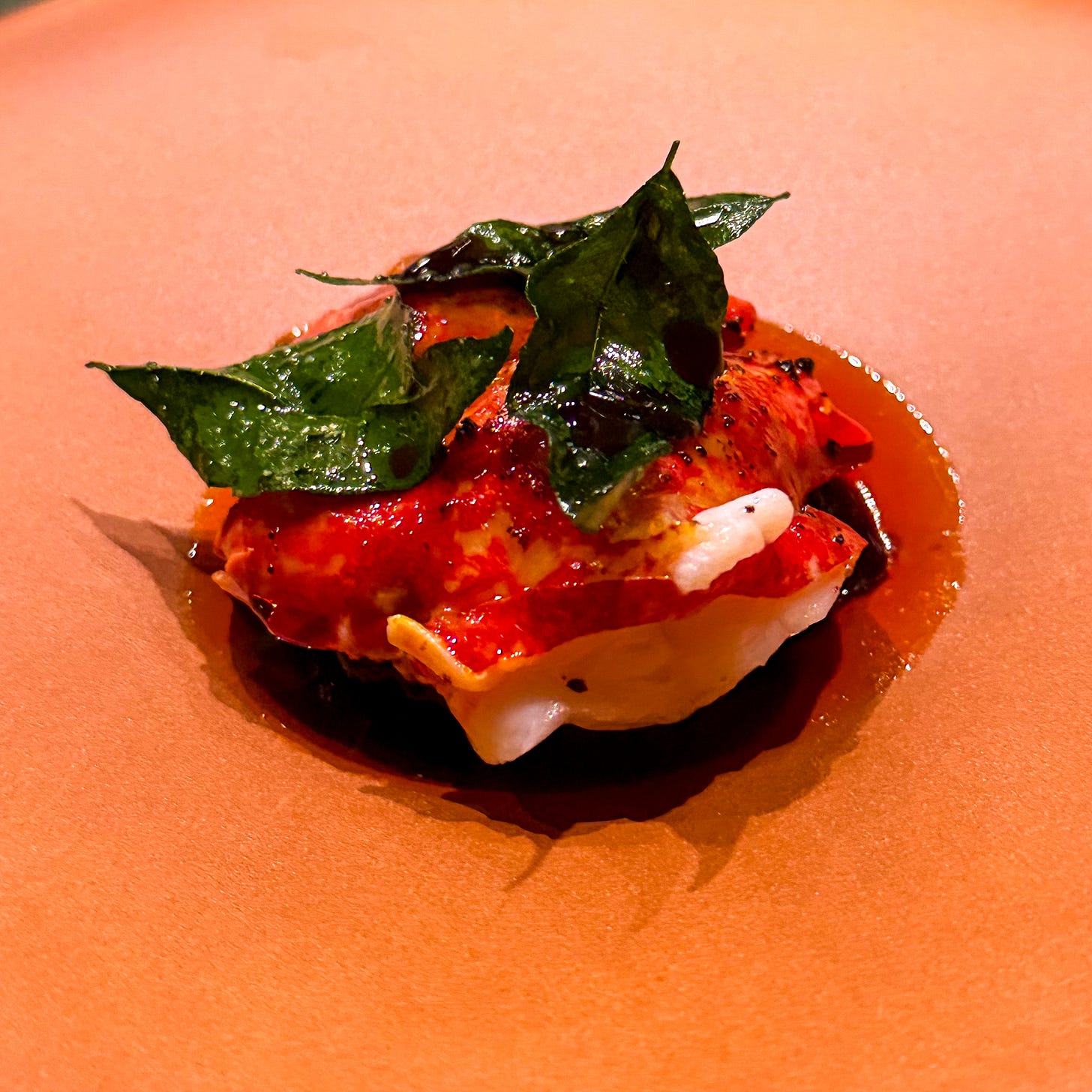 blue lobster with wilted spinach and orange nasturtium flowers in golden sambal sauce at Mantra restaurant