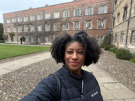 me smiling in front of historic college buildings at Jesus College in Cambridge UK