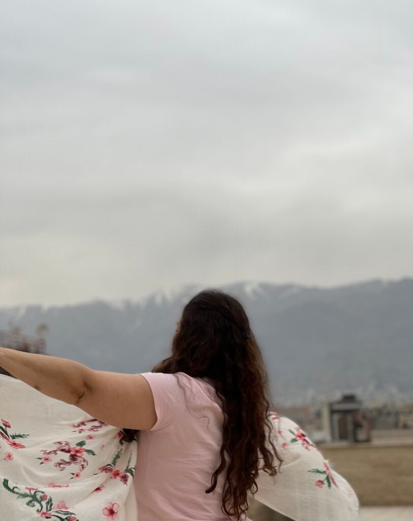 woman holding a sheet in front of the mountains