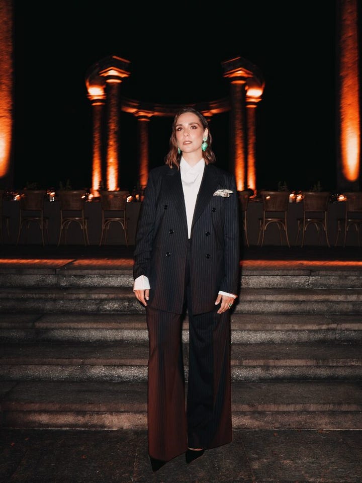 Two guests wearing dark pinstripe and brown tailored suits at Brioni’s evening event.