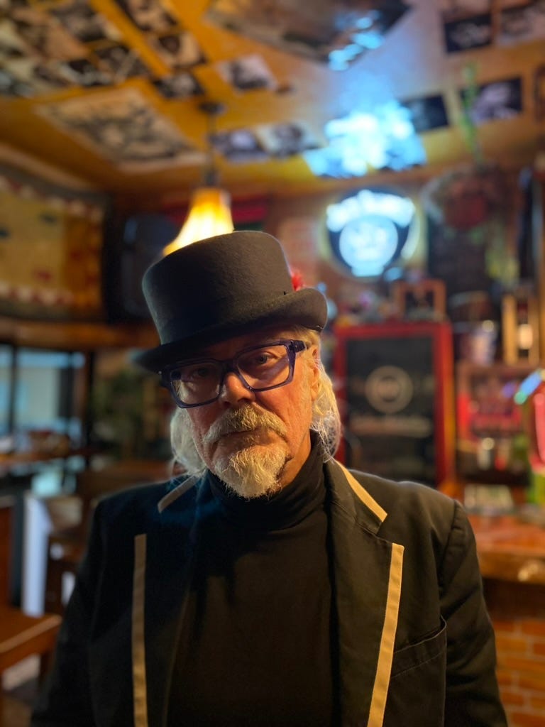 Man with top hat and great moustache in a bar