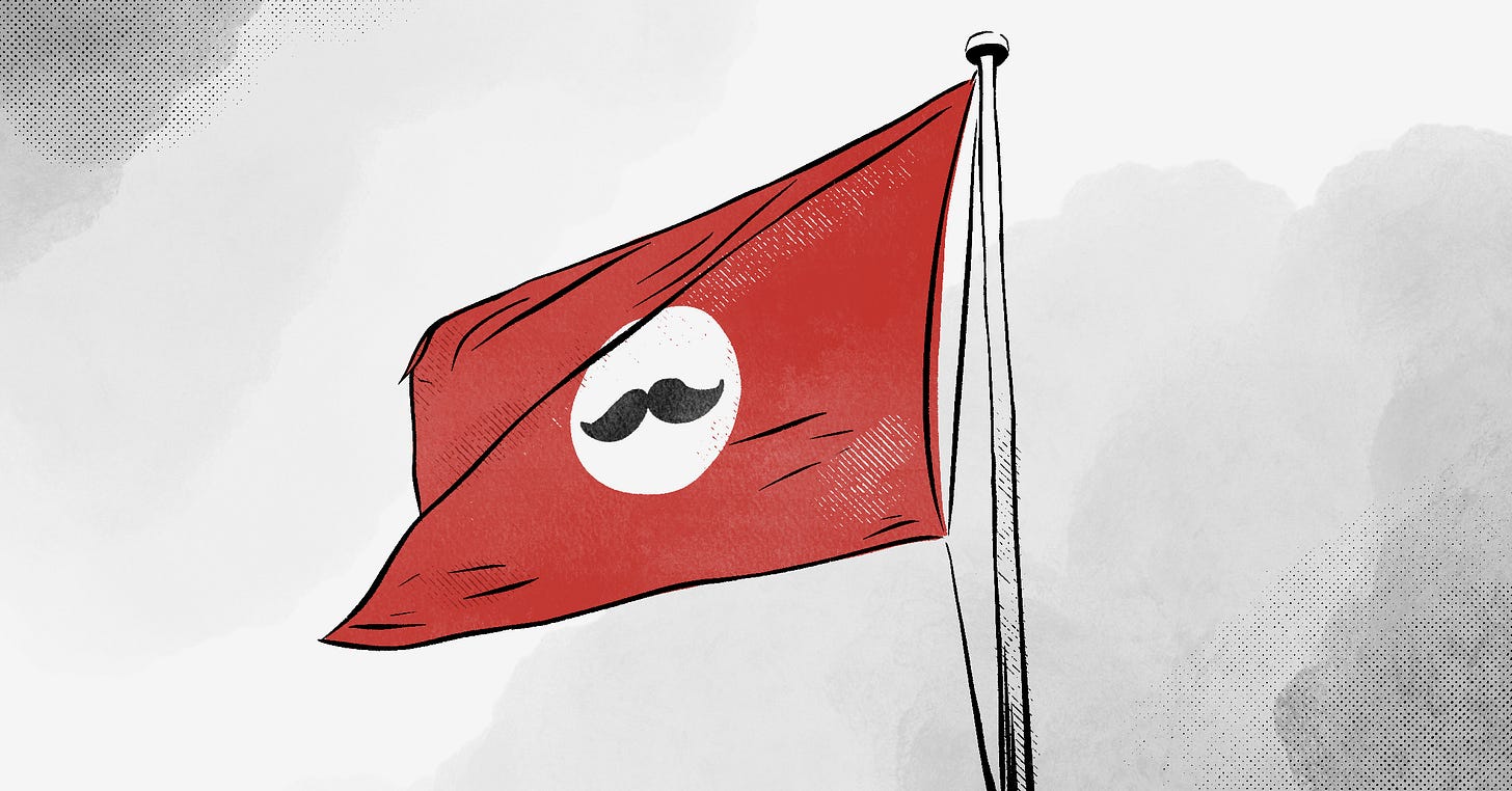 A flag with the appearance of a fascist emblem, but with a moustache. A flag with the appearance of a fascist emblem, but with a moustache.