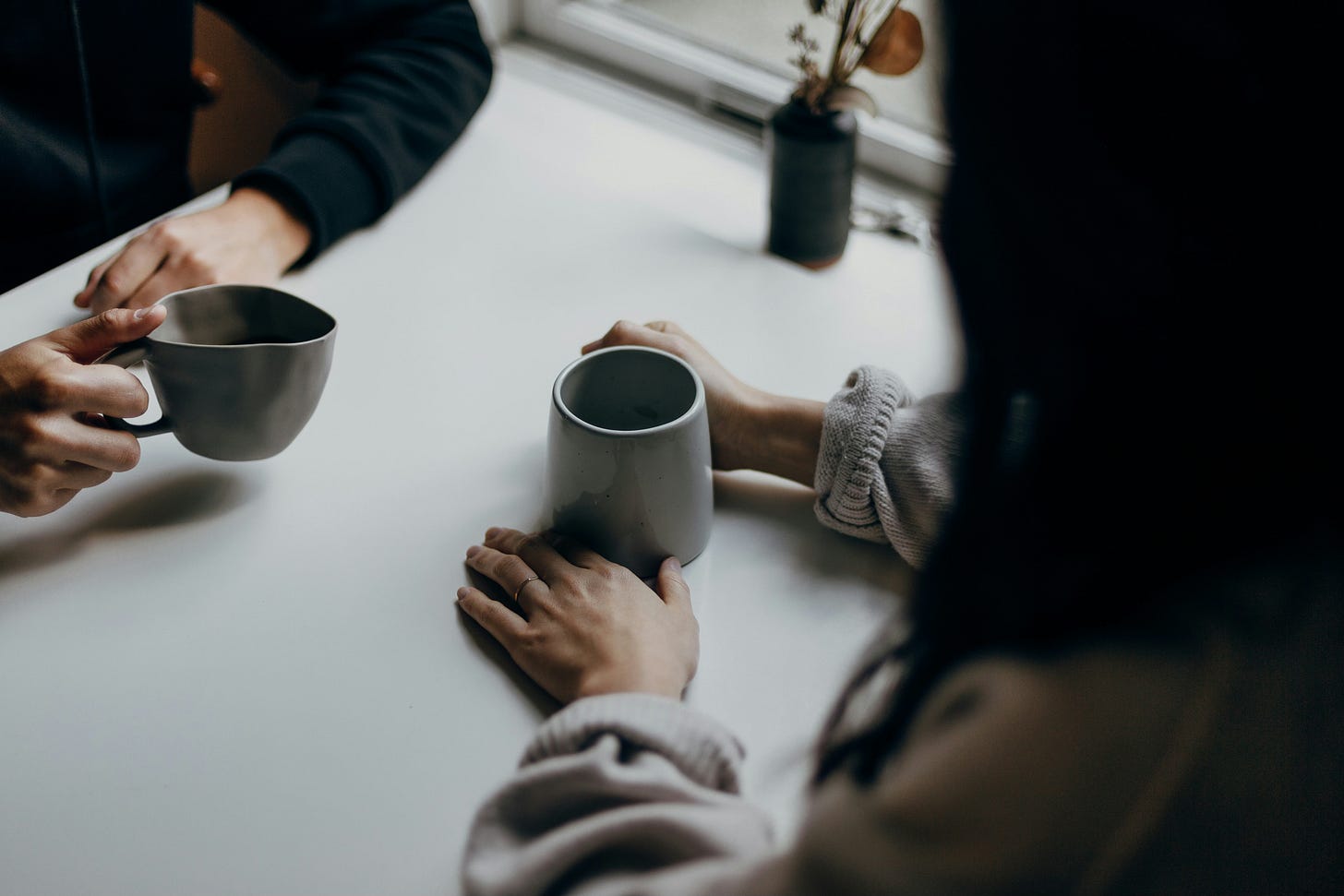Two people sit chatting over coffee