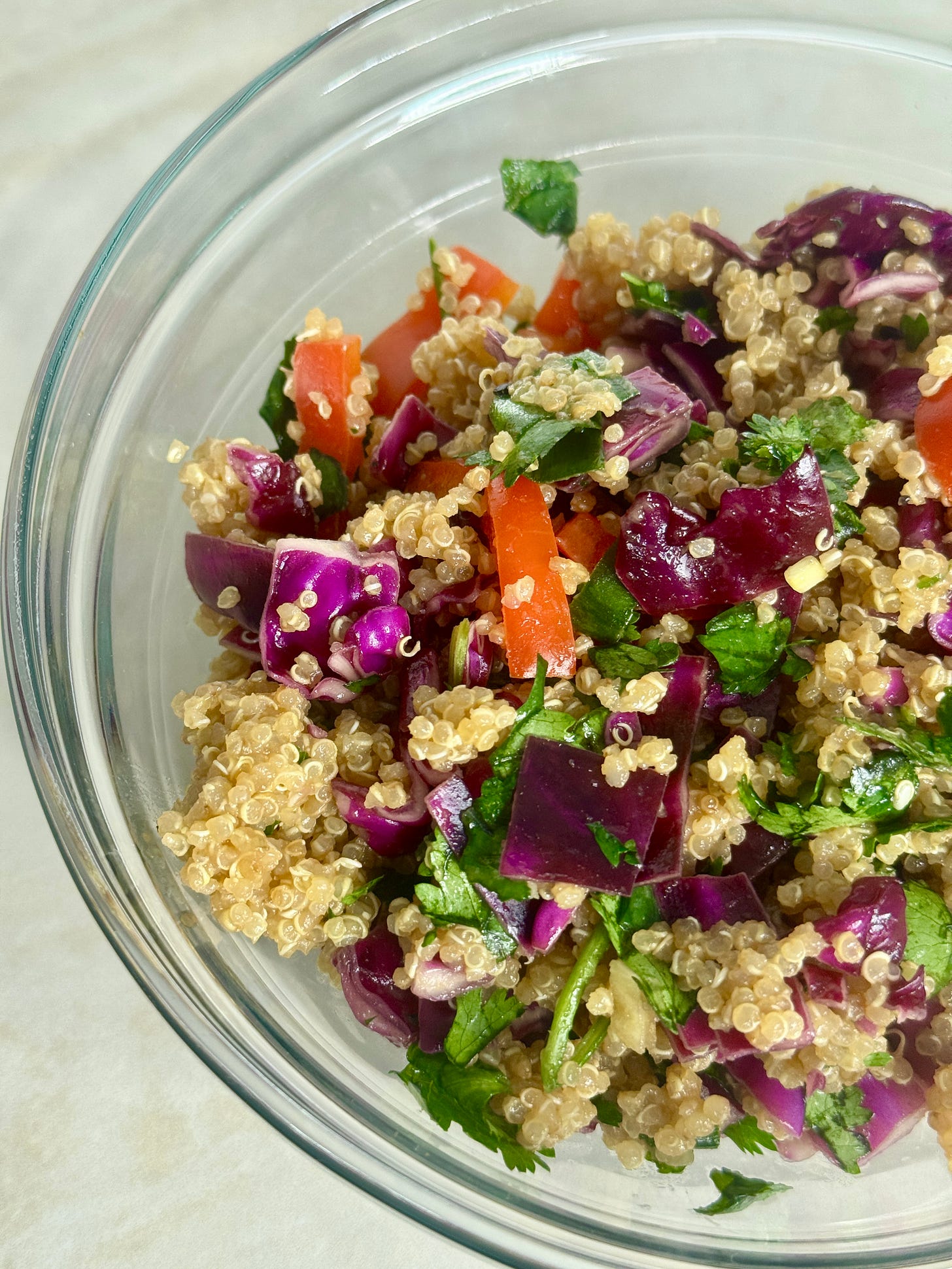 Colorful sesame quinoa salad with crunchy red bell pepper, purple cabbage, and green onions, tossed in a savory coconut aminos and sesame dressing