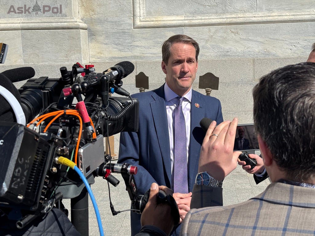A politician in a suit answers questions as TV cameras roll on a bright sunny day in Washington