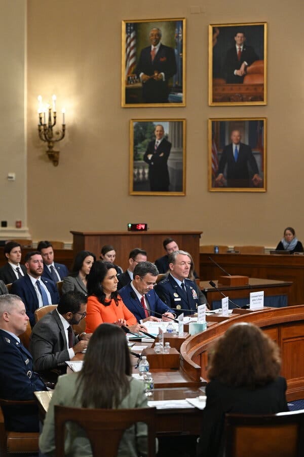 Members of the Trump administration, including Kash Patel, Tulsi Gabbard and John Ratcliffe, sit at a curved wooden table during a hearing. Members of the Trump administration, including Kash Patel, Tulsi Gabbard and John Ratcliffe, sit at a curved wooden table during a hearing.