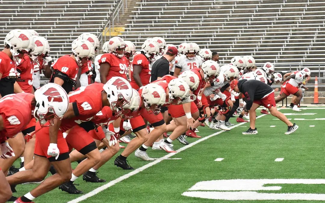 Wisconsin Badgers football players run sprints during fall camp practice. Wisconsin Badgers football players run sprints during fall camp practice.