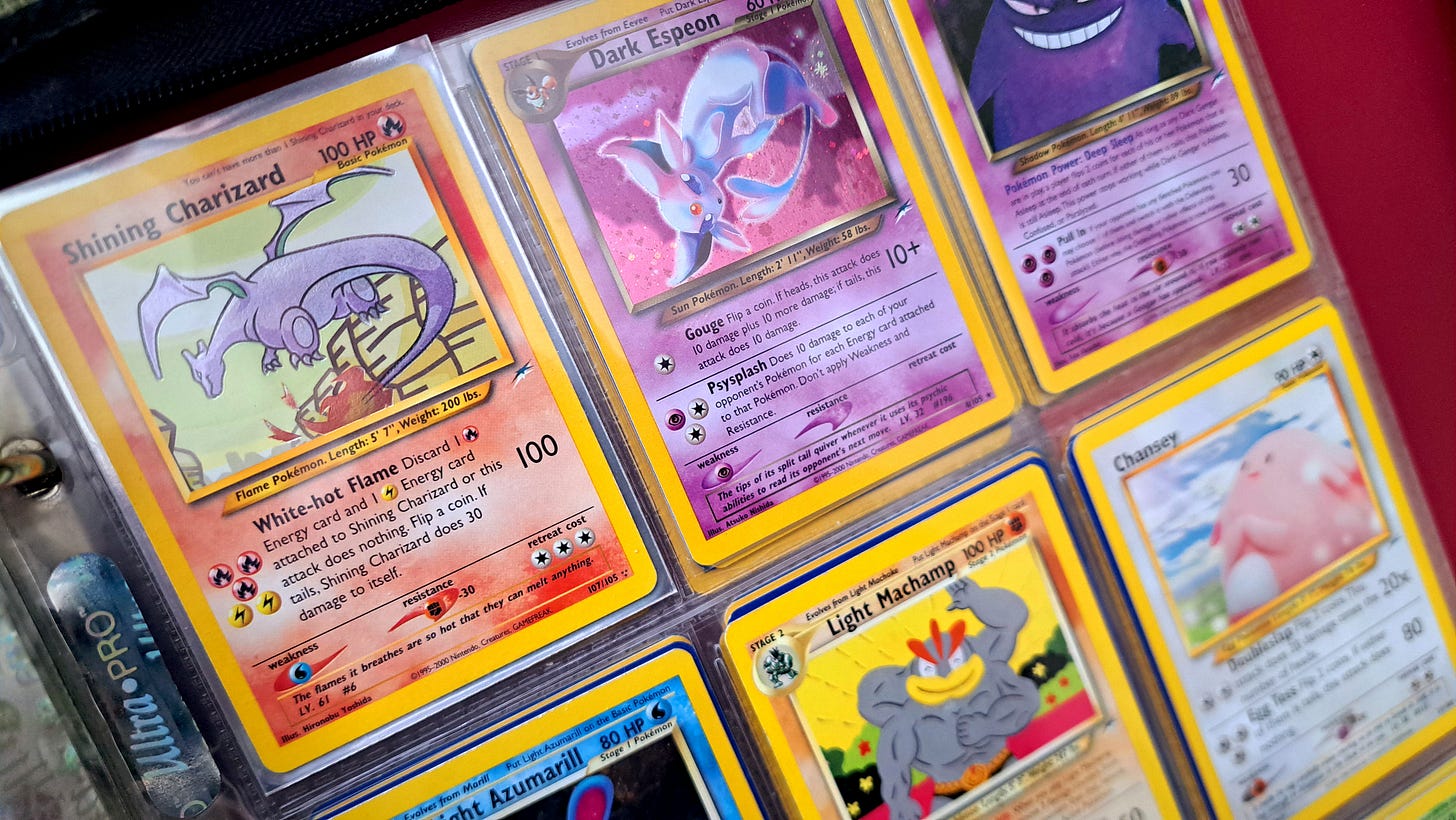 A photograph featuring some of Jay’s Pokémon trading cards, including his Shining Charizard card