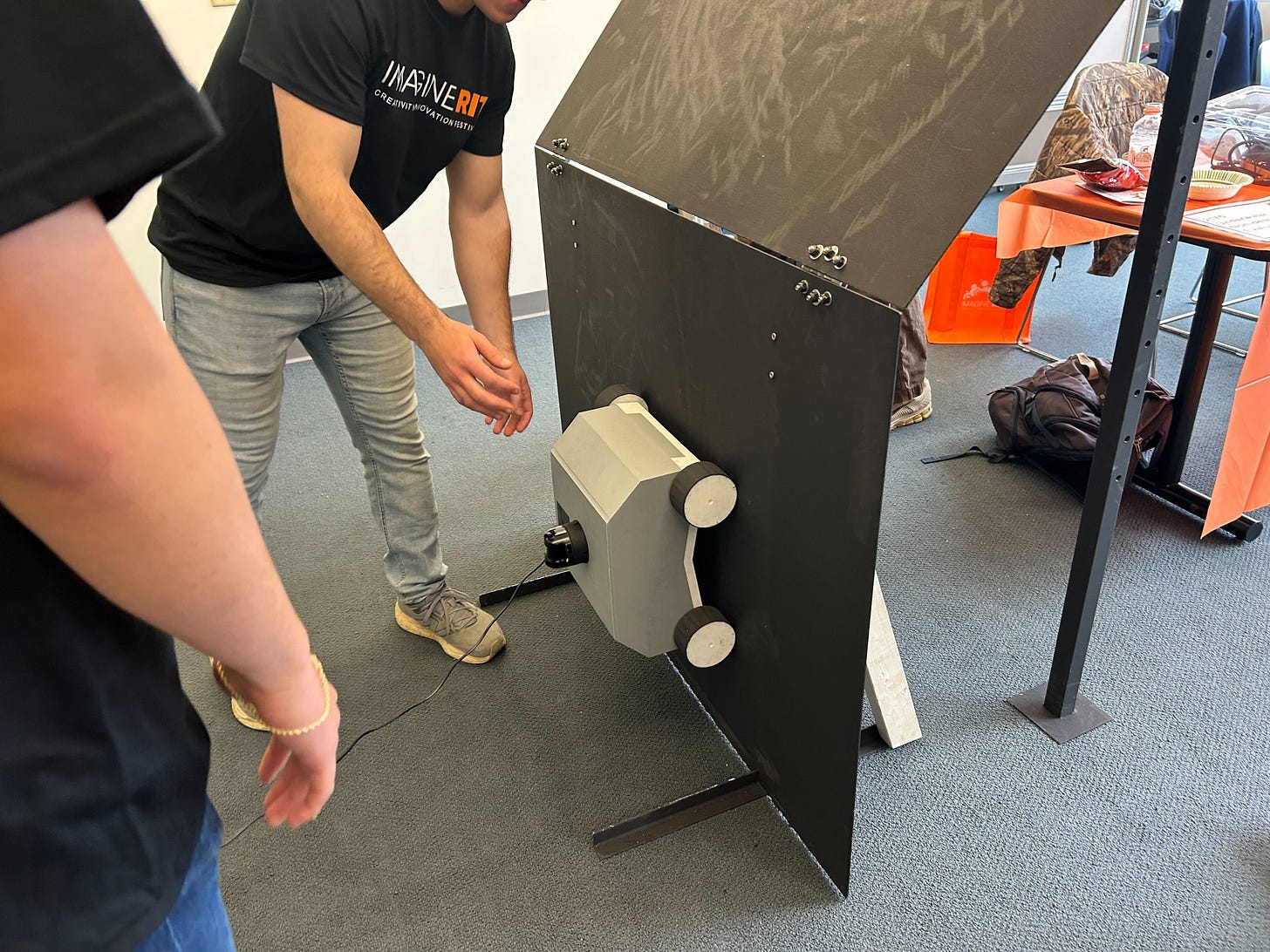 Image showing students demonstrating a hull-cleaning robot prototype at RIT