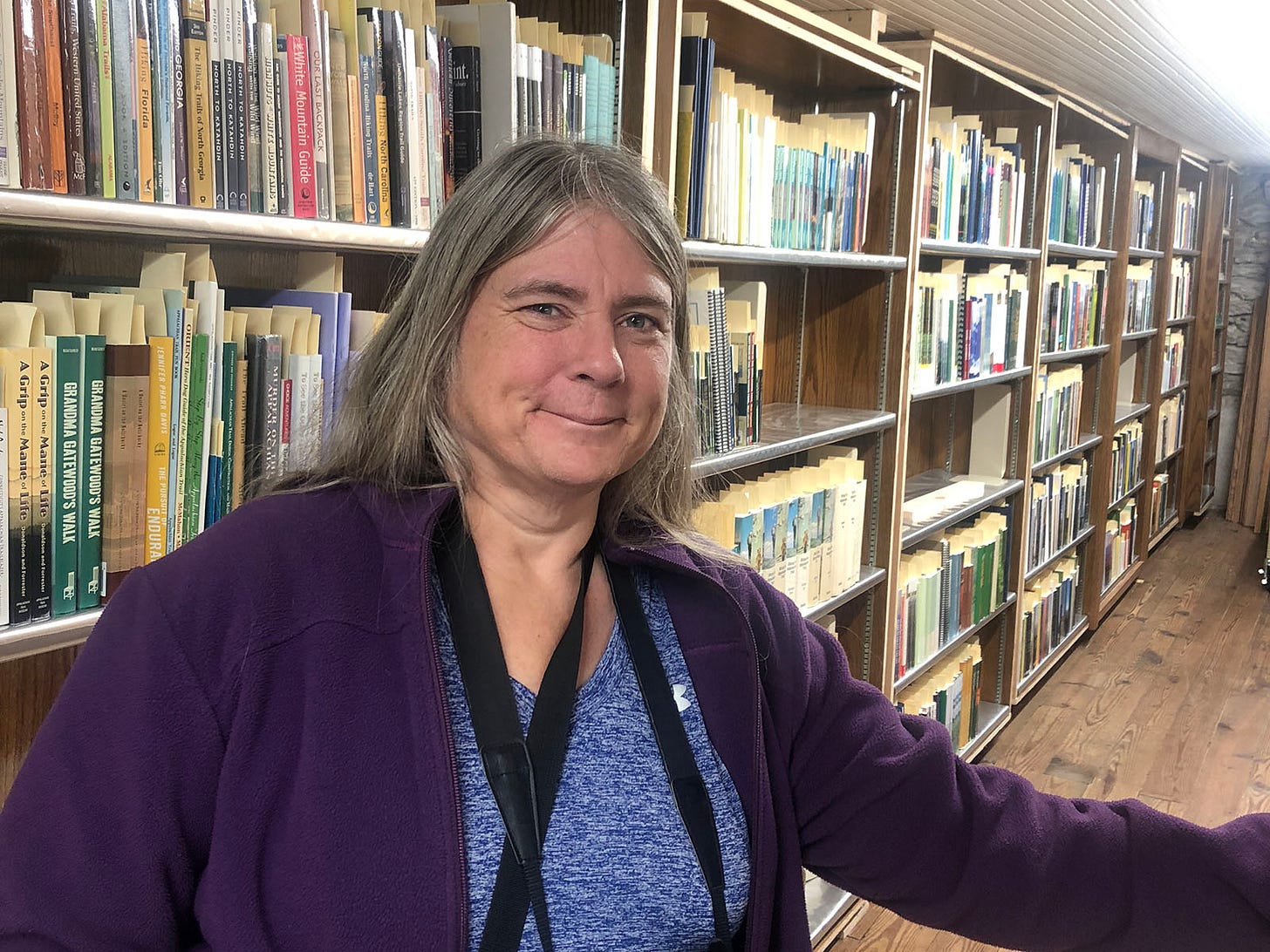 Woman with shelves of books behind her