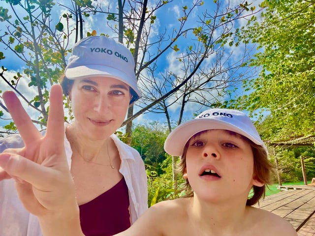 Sarah and her son wearing white Yoko Ono hats.