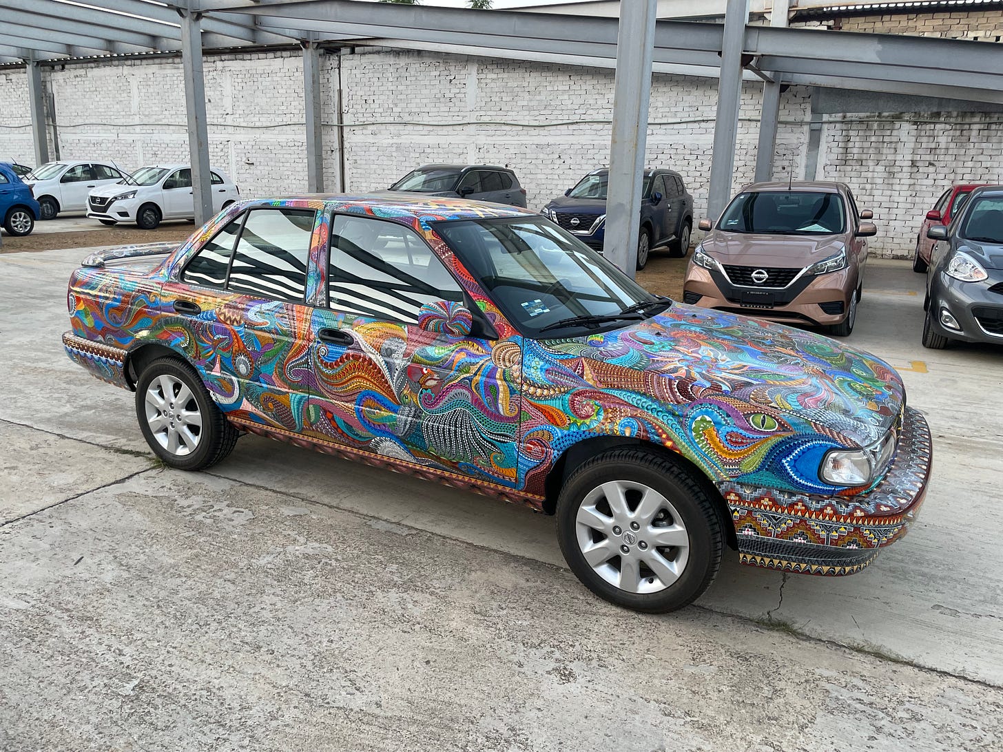 An elaborately painted Nissan sedan.