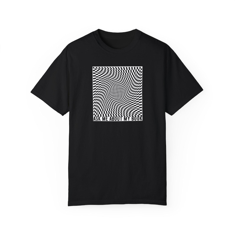 May include: A black t-shirt with a white checkered pattern that appears to be warping or moving. The text 'ASK ME ABOUT MY BOOK' is printed below the pattern.