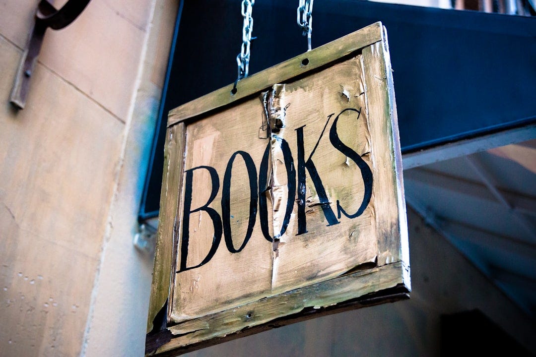 book signage hanging beside white wall book signage hanging beside white wall