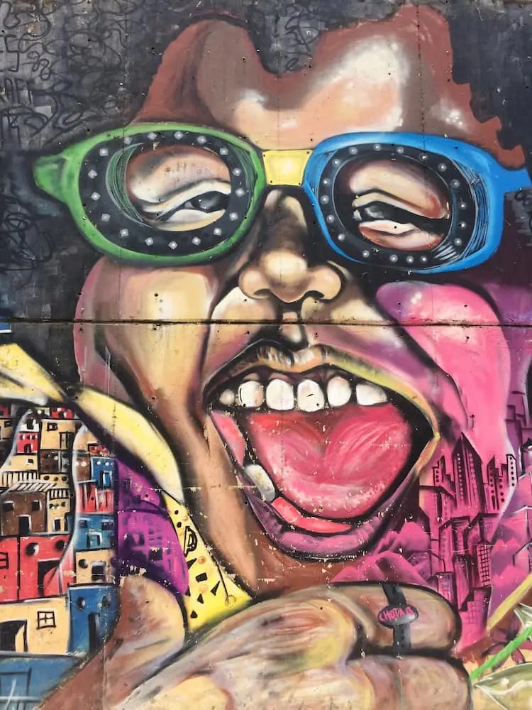 Street art - a laughing facing wearing glasses with blue and green frames