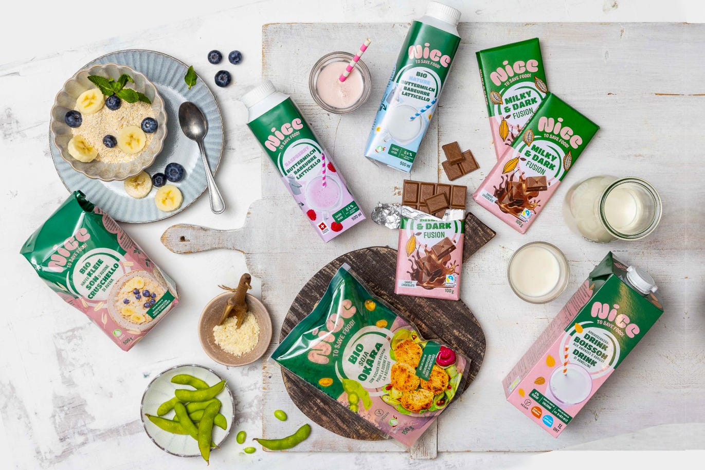 Auf einer weissßen Unterlage sind verschiedene Produkte der Coop-Eigenmarke ‚Nice to Save Food‘ in grün-pinken Verpackungen arrangiert, darunter pflanzliche Drinks und Lebensmittel aus bisher ungenutzten Nebenprodukten. Umgeben sind sie von Zutaten wie Blaubeeren, Bananenscheiben, Edamame und Schokolade. Auf einer weissßen Unterlage sind verschiedene Produkte der Coop-Eigenmarke ‚Nice to Save Food‘ in grün-pinken Verpackungen arrangiert, darunter pflanzliche Drinks und Lebensmittel aus bisher ungenutzten Nebenprodukten. Umgeben sind sie von Zutaten wie Blaubeeren, Bananenscheiben, Edamame und Schokolade.