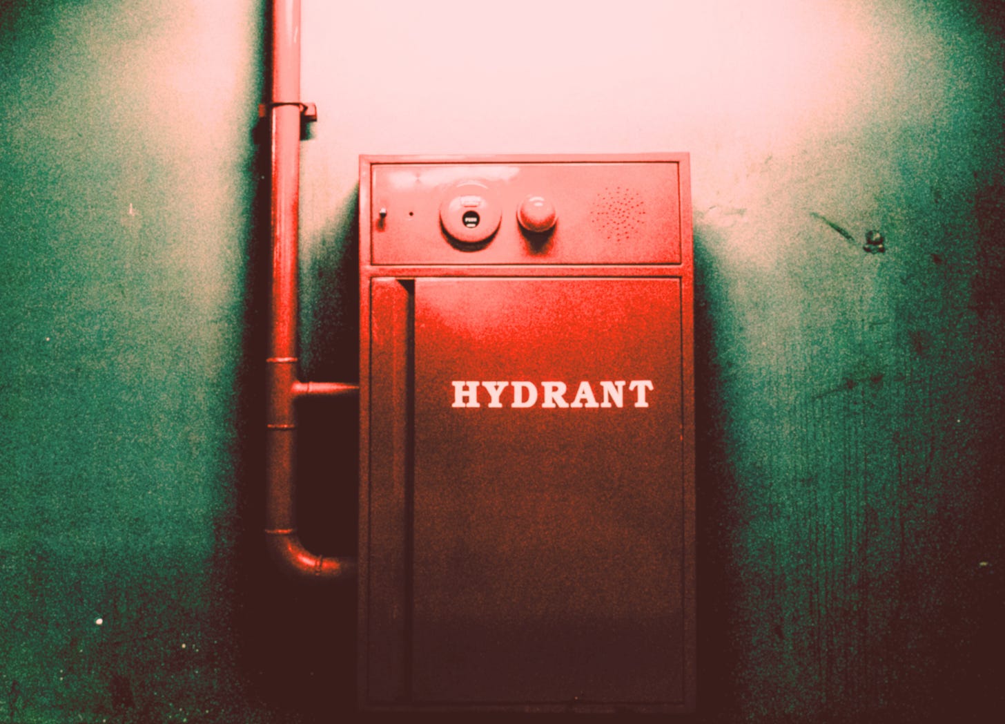 A vintage red fire hydrant mounted on an old wall—symbolizing the instinct to treat every emotional flare-up as an emergency, even when calm presence is what’s really needed.