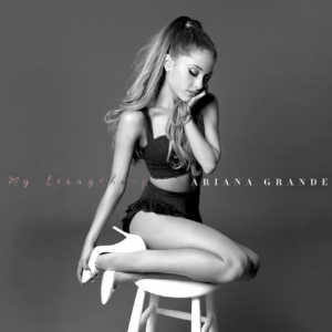 Ariana Grande kneeling on a stool, with her head resting on her hand Ariana Grande kneeling on a stool, with her head resting on her hand