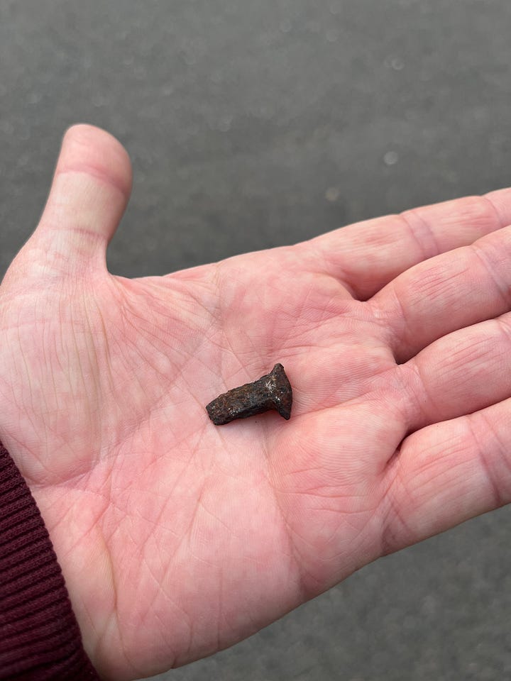 four photos of metal spikes or chunks I've picked up off the ground. The bottom left looks like a very old, hand made nail from the 1800s