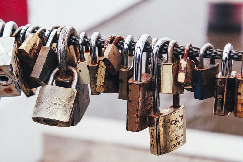 a bunch of locked padlocks on a thick steel cable.
