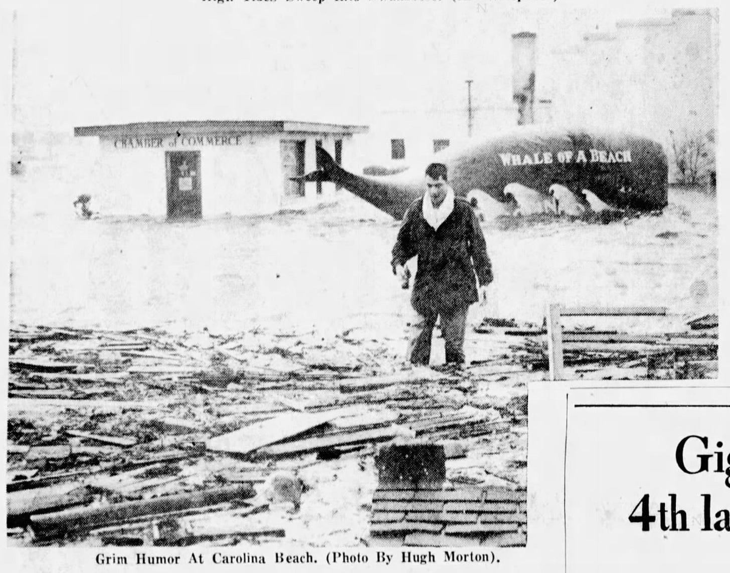 Scheer walking through flood in front of whale and chamber of commerce
