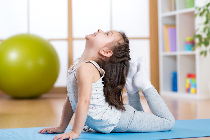 Little girl performing gymnastics on mat