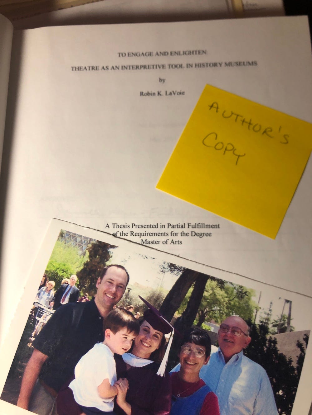 Cover page of master's thesis and a photo of the graduate with her family and young son.