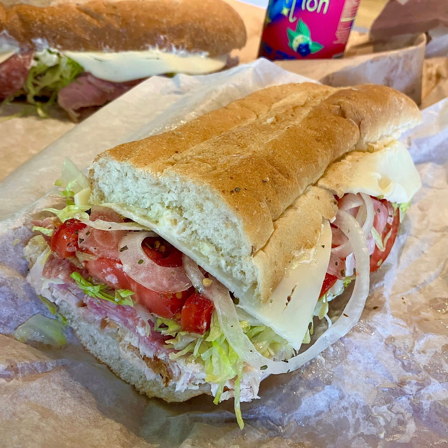 May be an image of sub sandwich, club sandwich, baguette and text