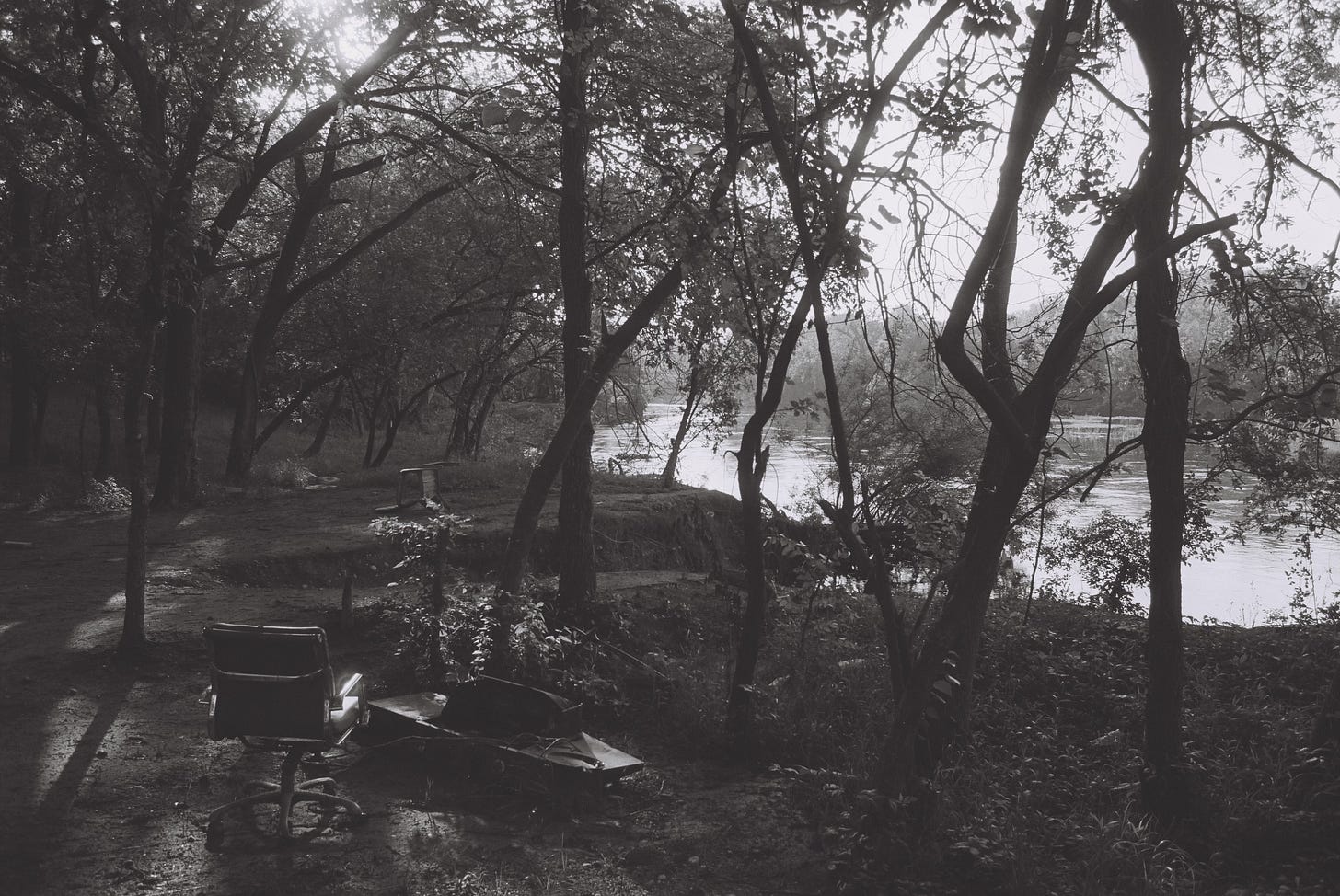 Black & white photo of camp by riverside