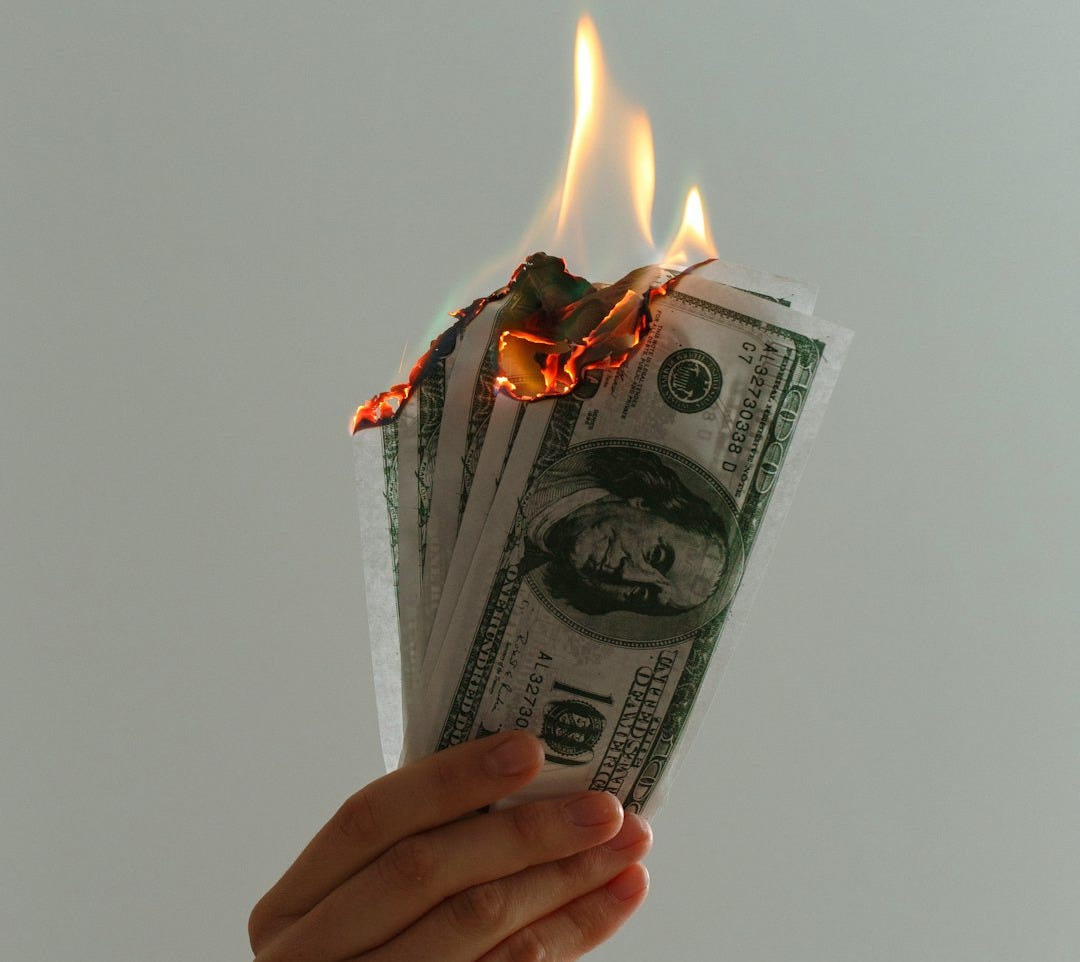 time lapse photography of several burning US dollar banknotes
