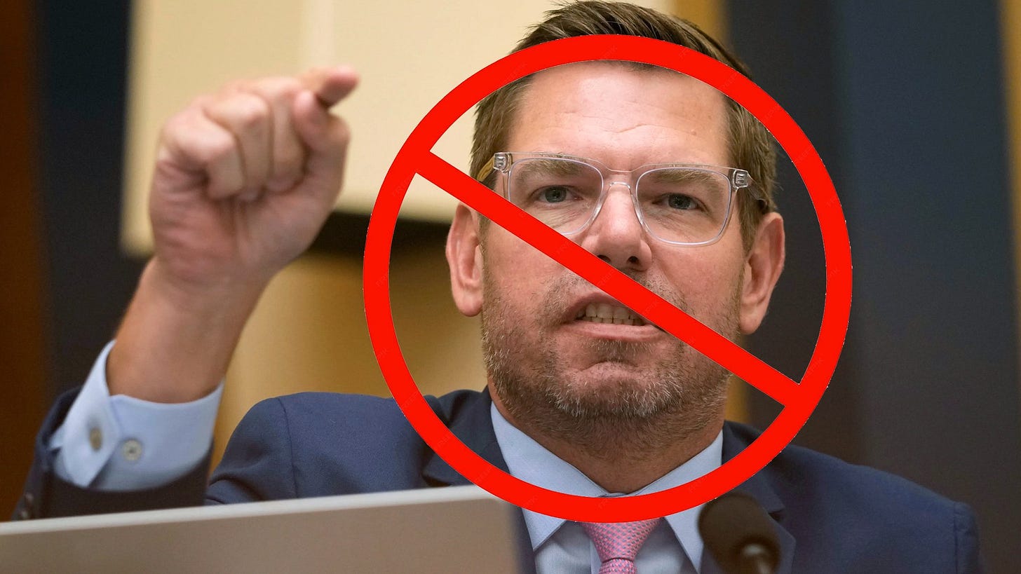 A politician gestures emphatically during a debate, emphasizing a point while seated at a table in a formal setting.
