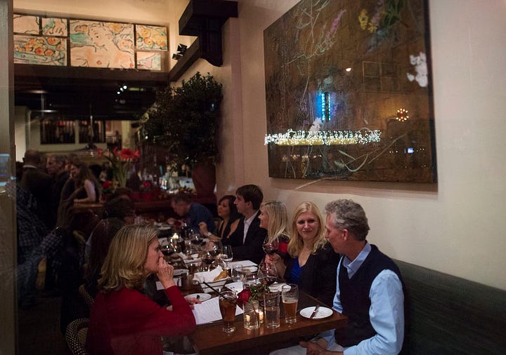 people in a restaurant in New York, a restaurant kitchen with plates, a busy dining room in a NYC restaurant
