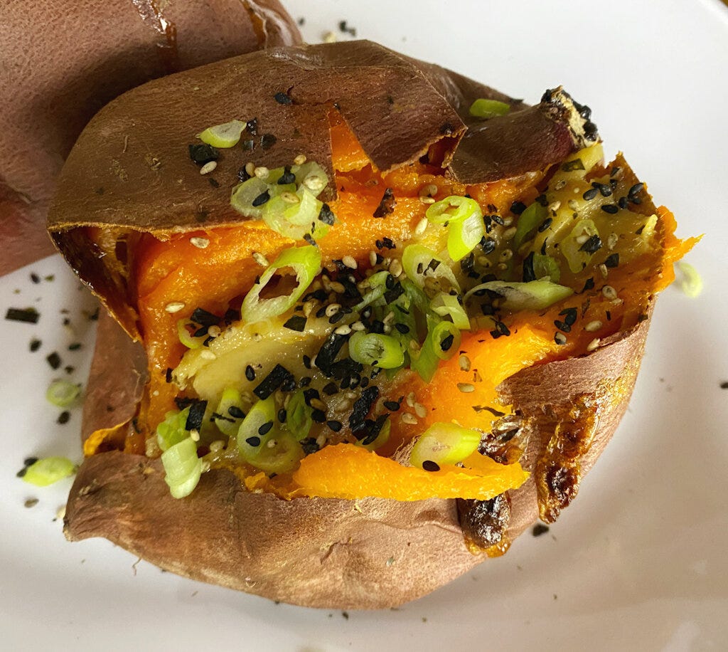 Roasted sweet potato slathered with miso butter and garnished with sliced scallion and furikake.