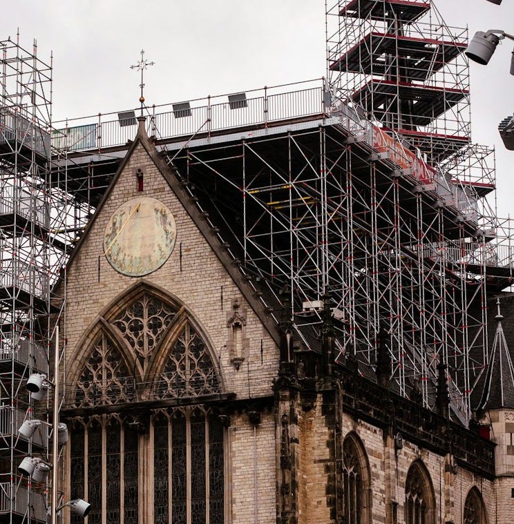 Church undergoing renovation with extensive scaffolding.