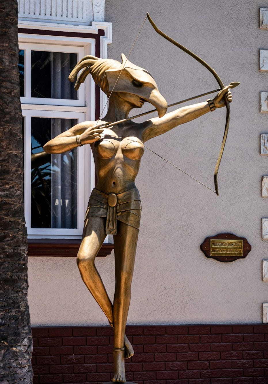 brown wooden statue on brown brick wall