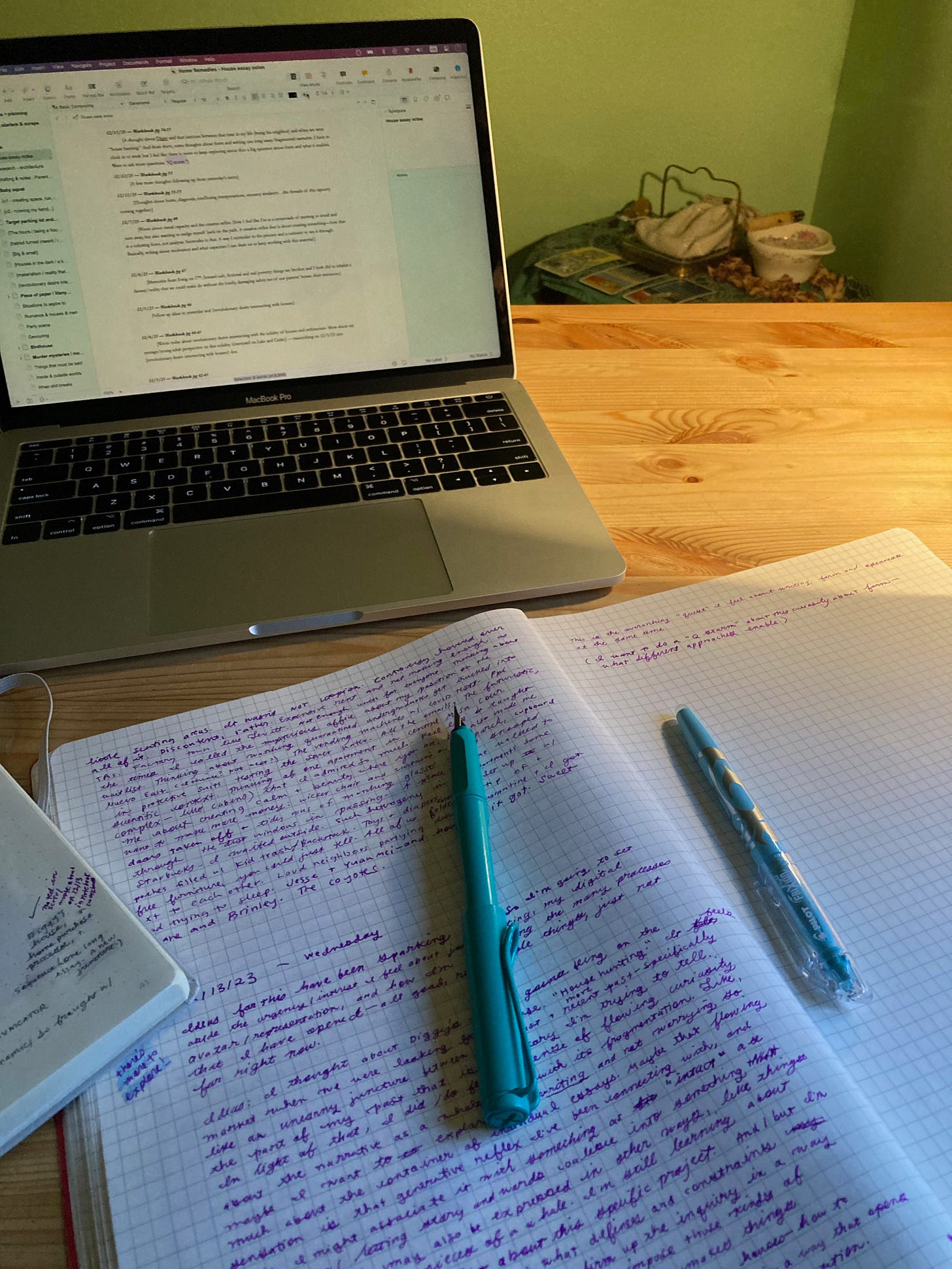 A notebook with pens and computer on a desk