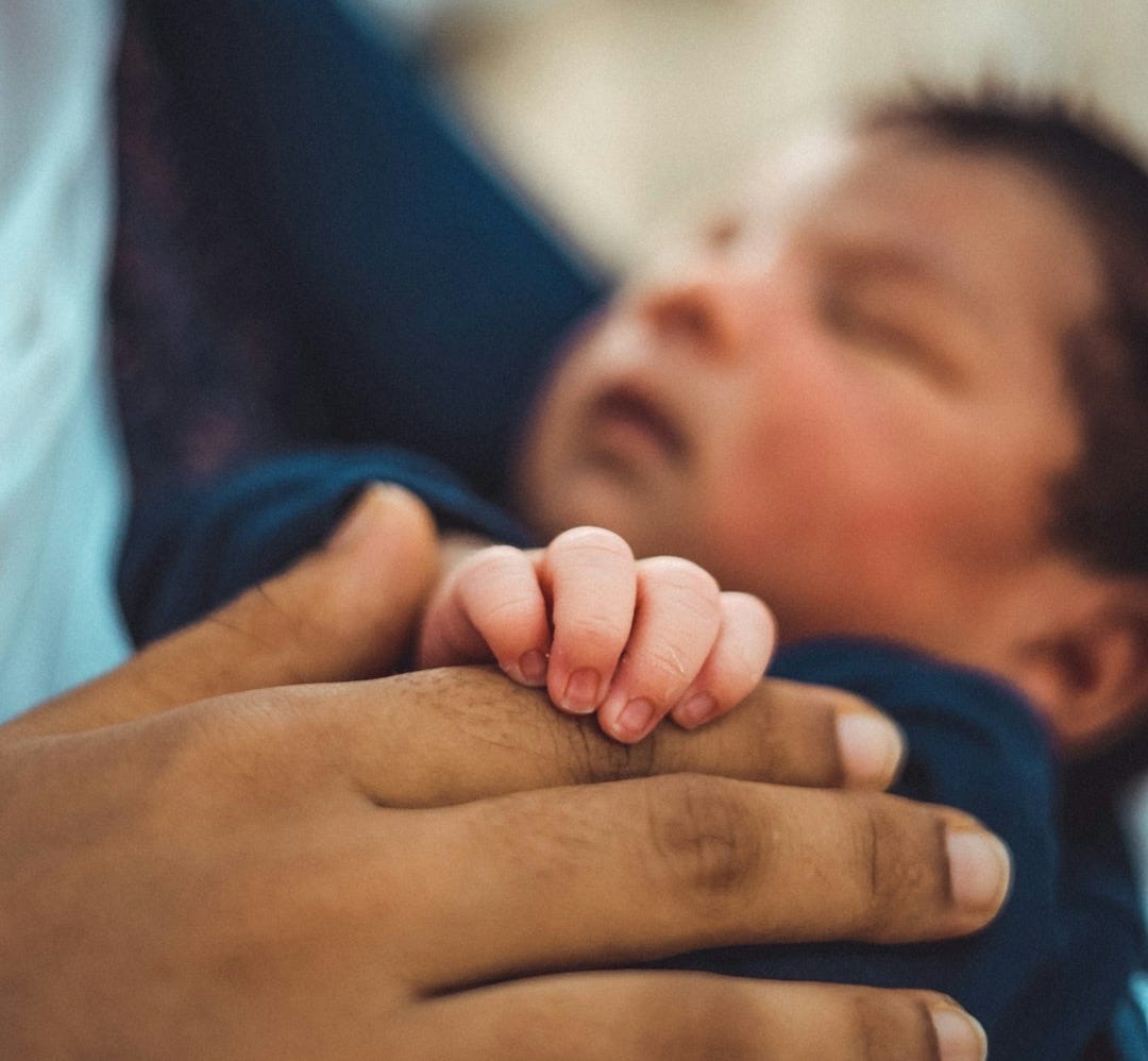 a man holding a baby in his arms a man holding a baby in his arms