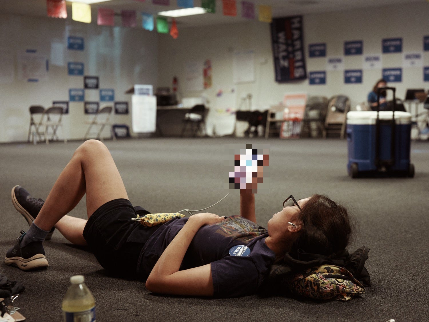 A woman relaxes laying on the ground at the Harris Walz campaign office taken by LA portrait and documentary photographer Afonso Salcedo A woman relaxes laying on the ground at the Harris Walz campaign office taken by LA portrait and documentary photographer Afonso Salcedo