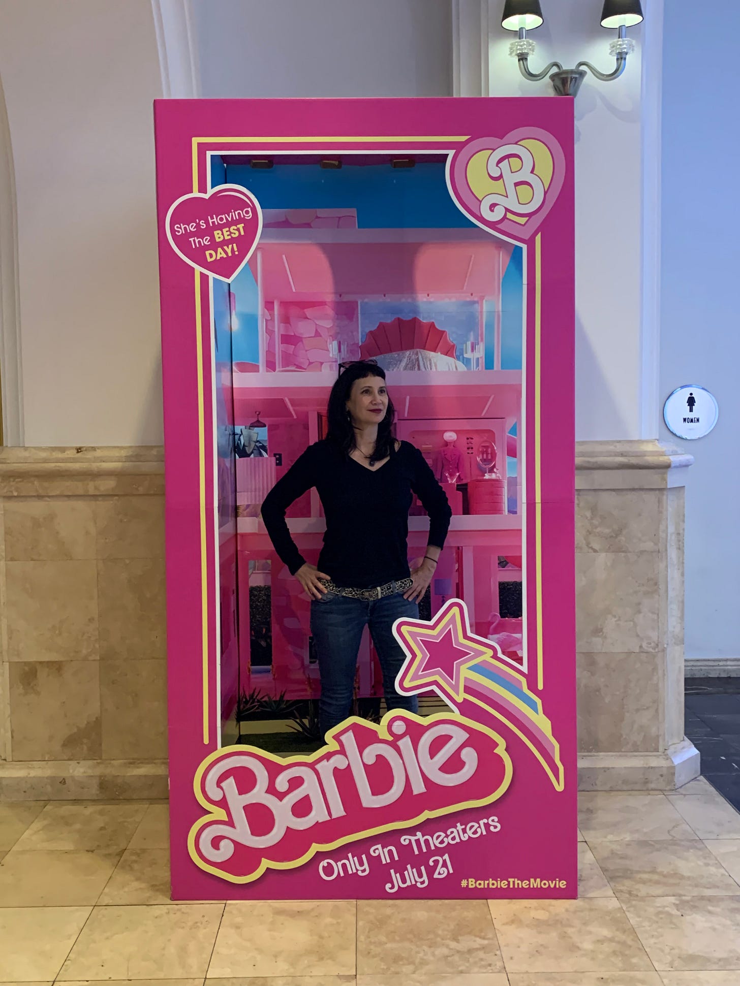 Laverne standing in front of a promotional display for the Barbie movie