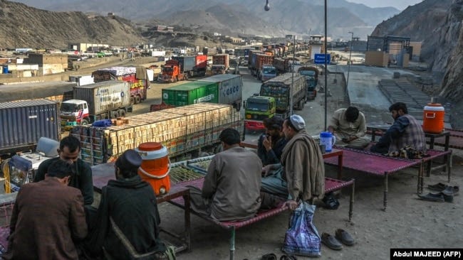 Drivers rest as stranded trucks are pictured near the Pakistan-Afghanistan border at Torkham on January 16. 