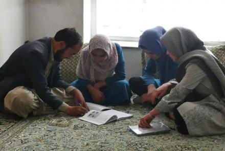A group of people looking at a paper

Description automatically generated with low confidence