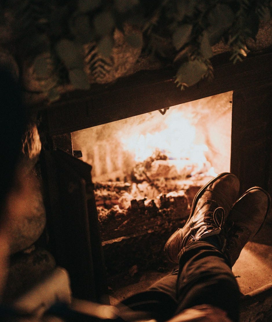 man sitting in front of the fireplace man sitting in front of the fireplace