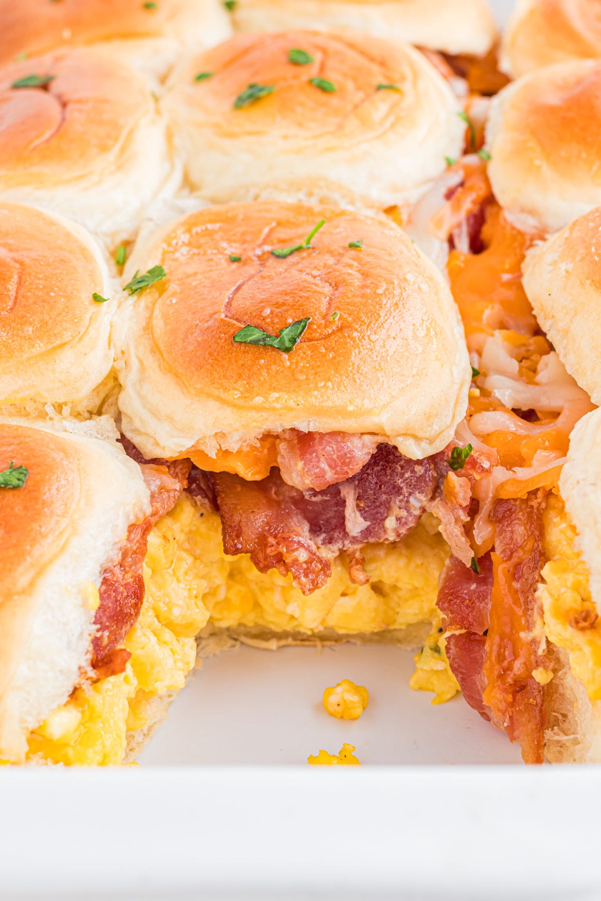 Breafast slider with scrambled eggs and bacon in pan.