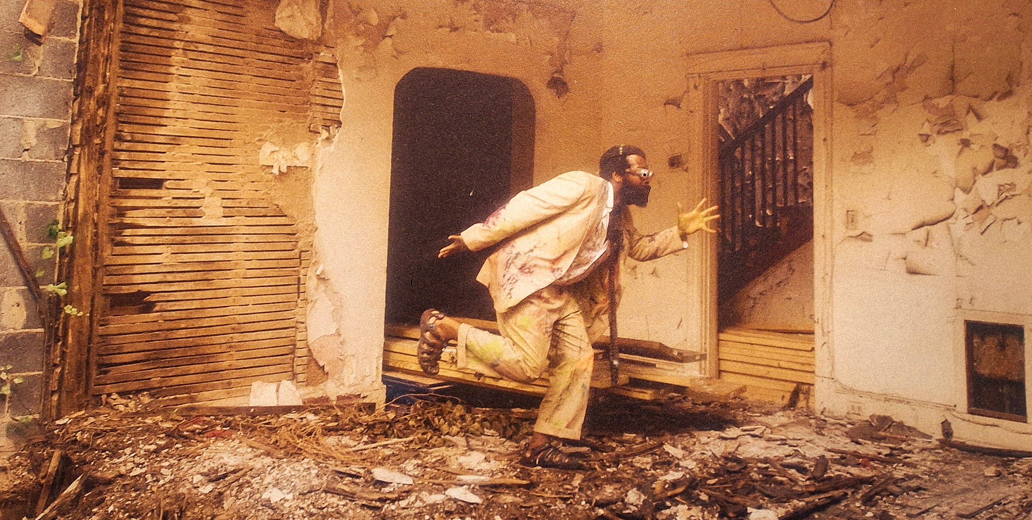 A black man running in ruins. Some artwork on the wall of a cafe/event center in D.C.