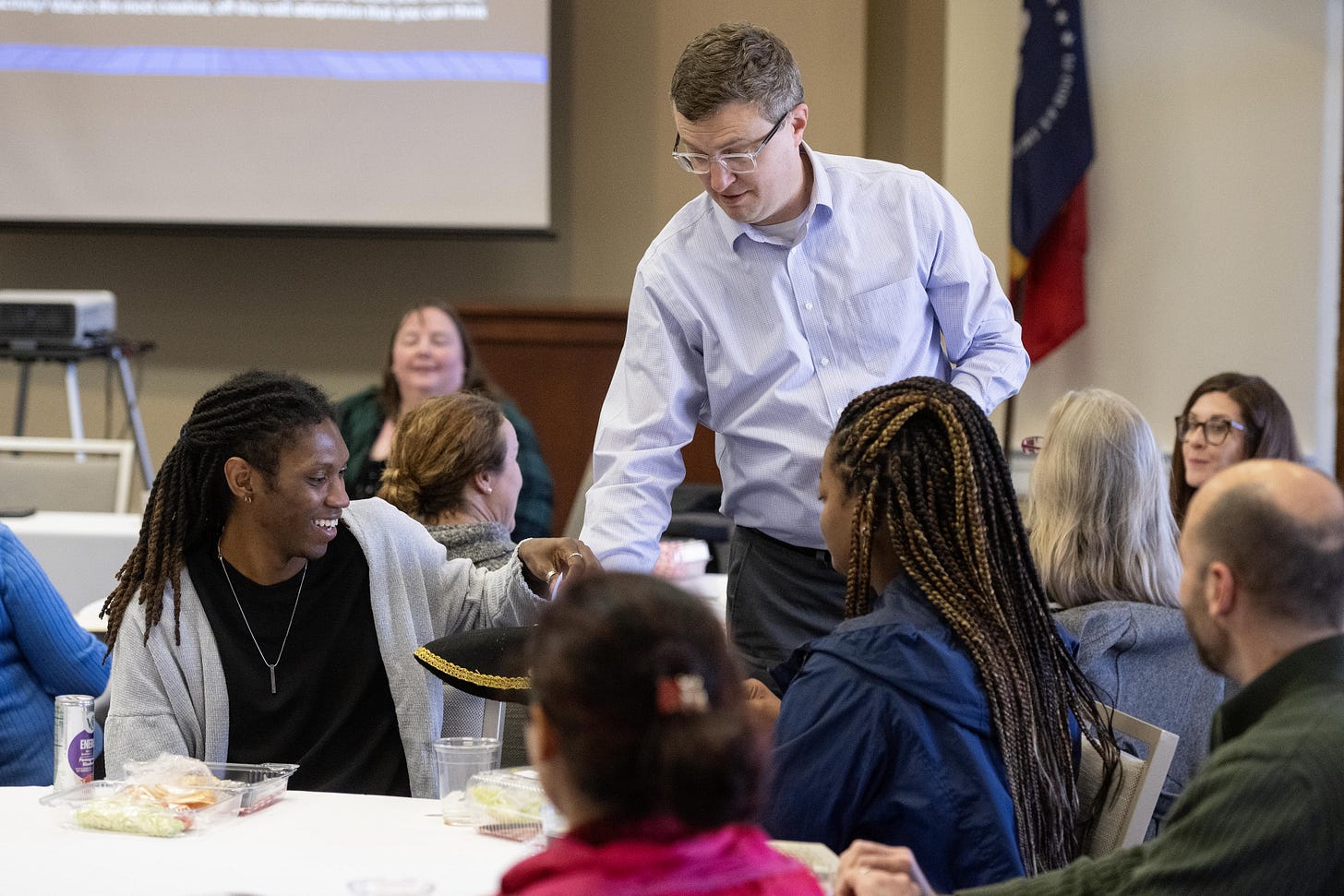 Derek Bruff holds out a tri-corner hat as a workshop participant draws out a slip of paper