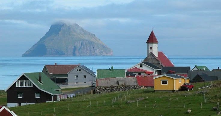 This may contain: a small village on the side of a hill with a mountain in the back ground