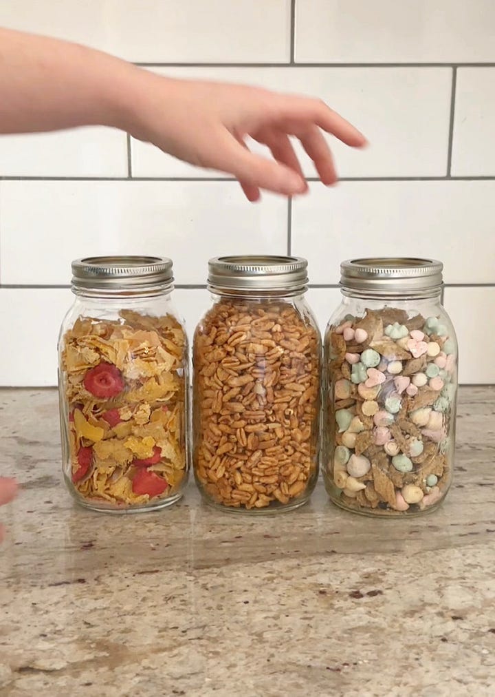 A variety of different homemade cereals in large glass jars.