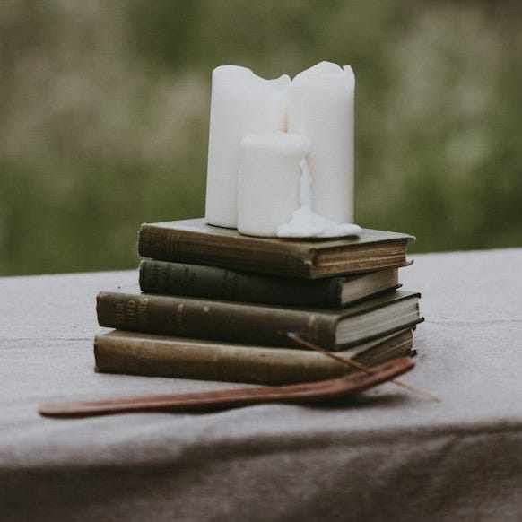 white pillar candle on books white pillar candle on books