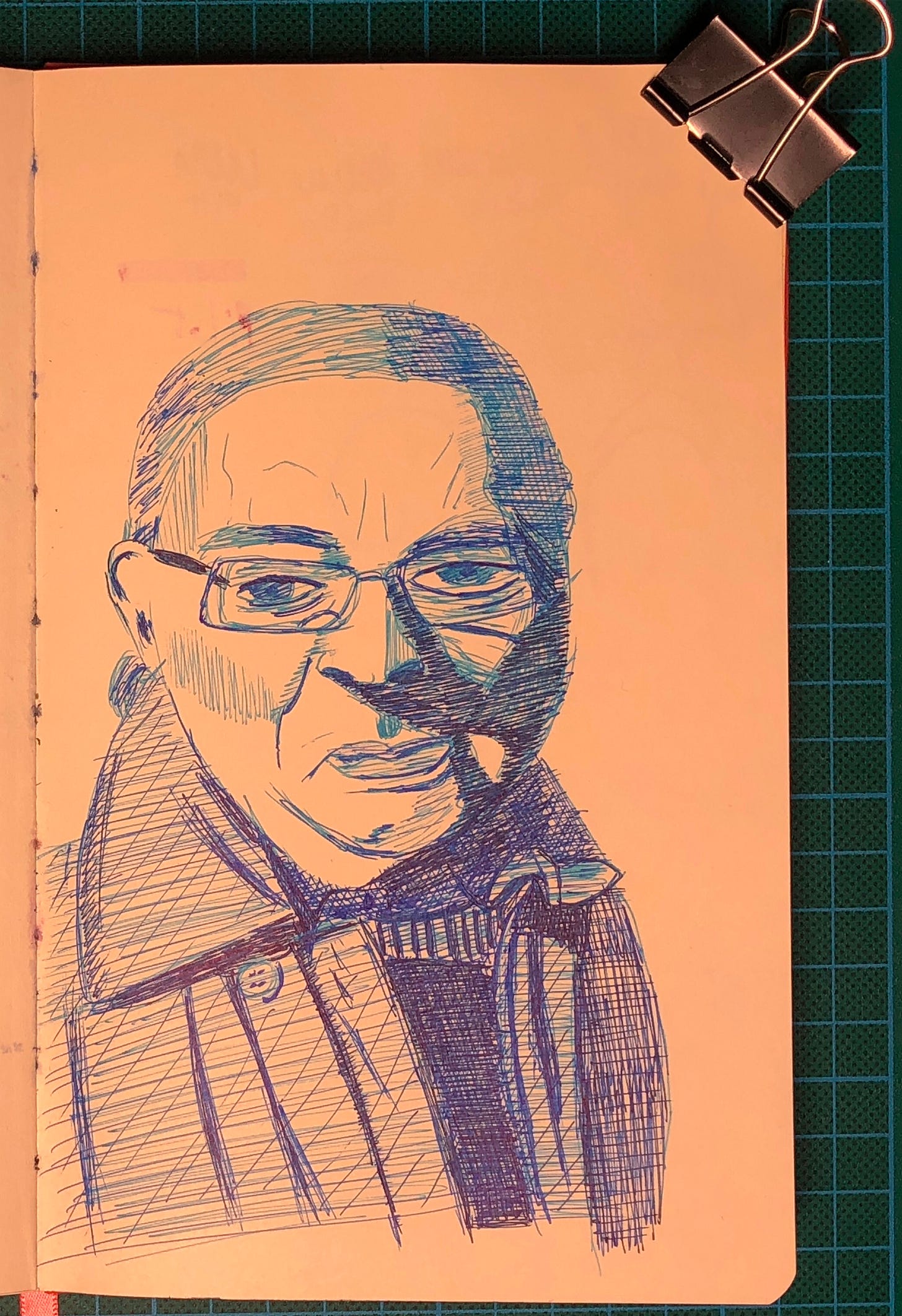 Photo d'une page de mon sketchbook où j'ai dessiné un portrait avec des stylos à bille de 3 valeurs de bleu différentes.
